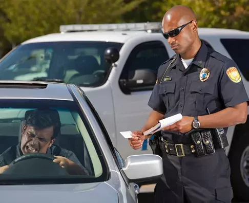 Police officer speaking with a driver during a traffic stop about window tint